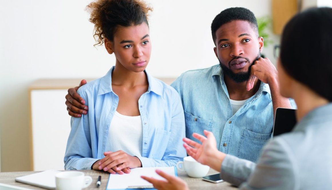 Serious Black Couple Listening To Financial Advisor During Investment Consultation