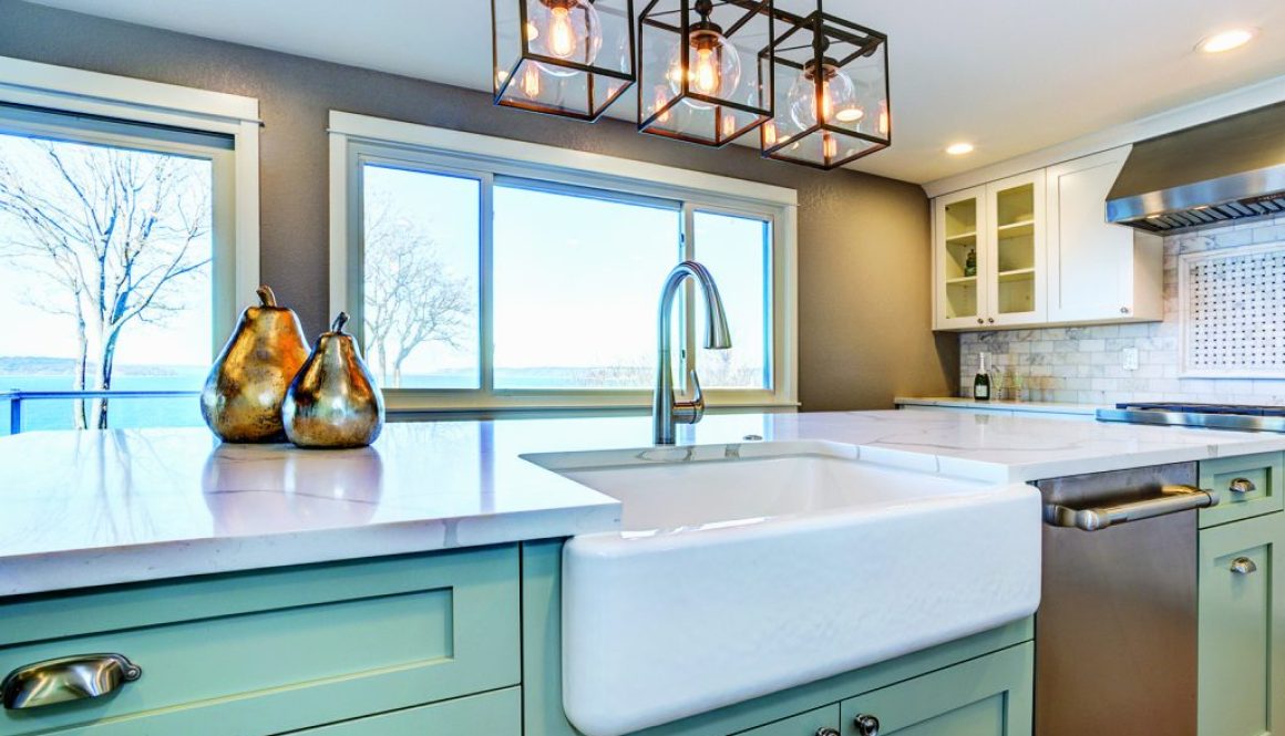 Beautiful kitchen room with green island and farm sink.