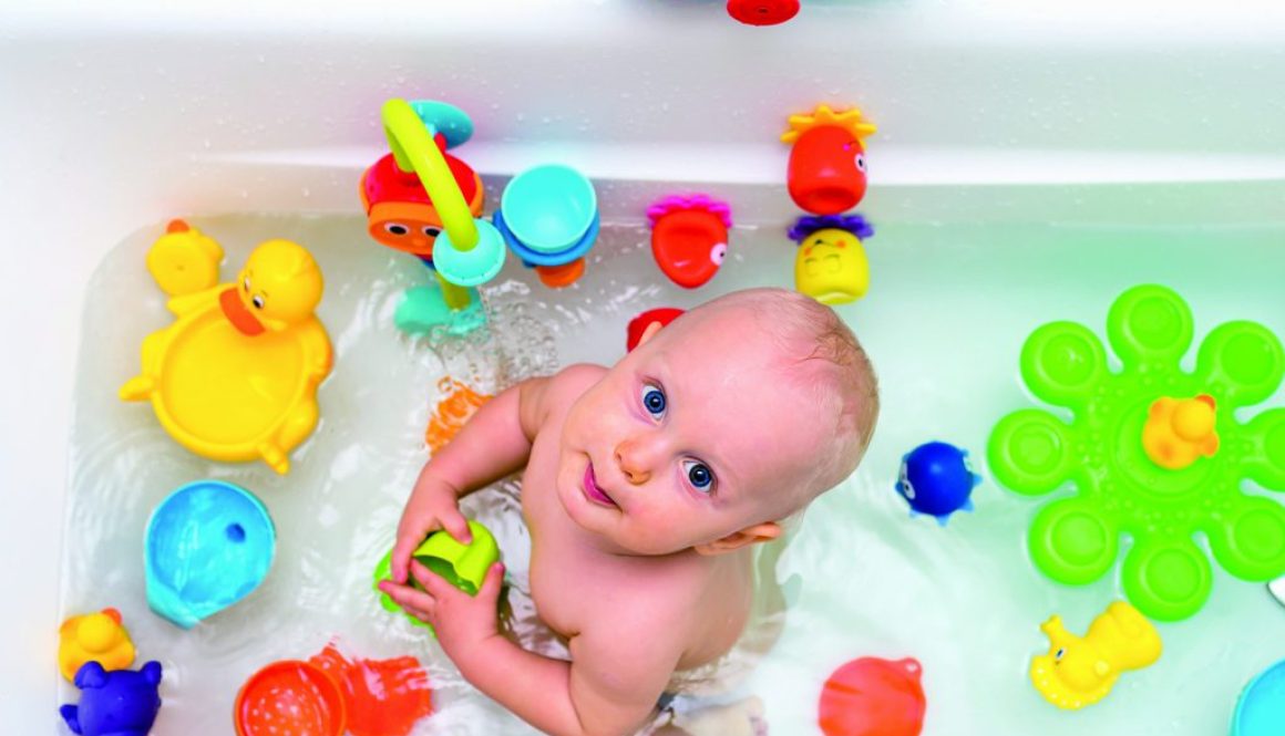 Baby boy taking a bath, playing with colorful toys