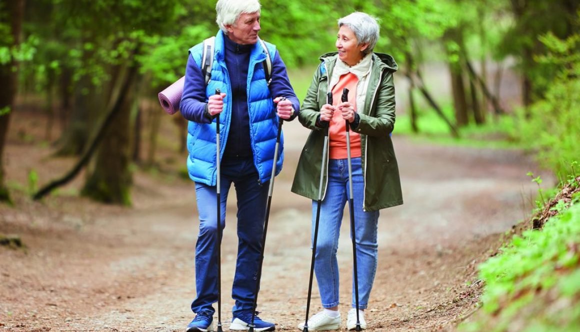 Cheerful Senior Couple Enjoying Nordic Walk in Forest