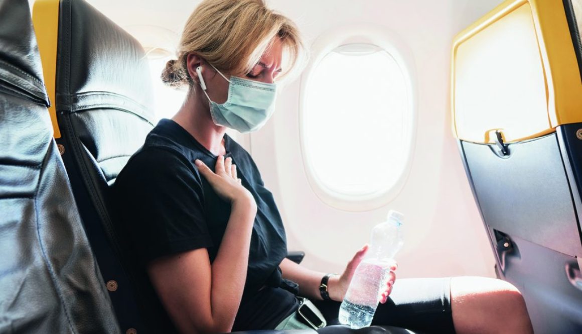 Woman wearing prevention mask during a flight inside an airplane