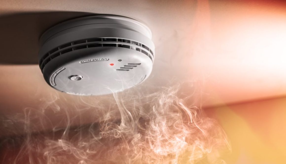 Smoke detector and interlinked fire alarm in action background